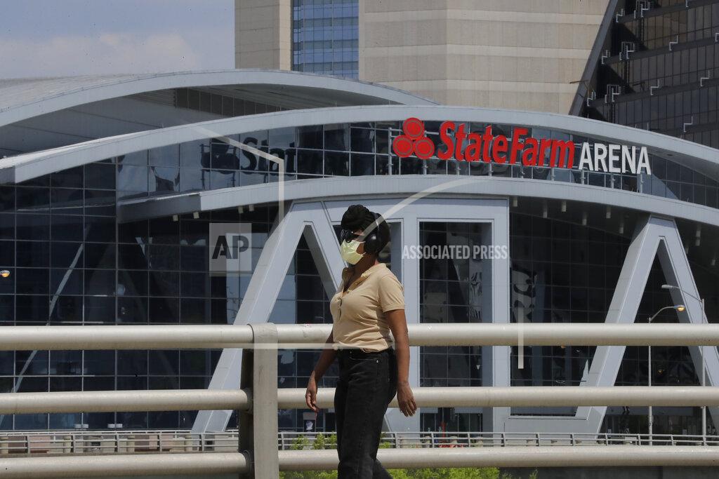 Brynn Anderson A person wearing a mask walks near the StateFarm Arena where the men's Final Four NCAA college basketball championship game was to be played on Monday, April 6, 2020, in Atlanta. The entire NCAA tournament was canceled due to the COVID-19 virus. (AP Photo/Brynn Anderson)