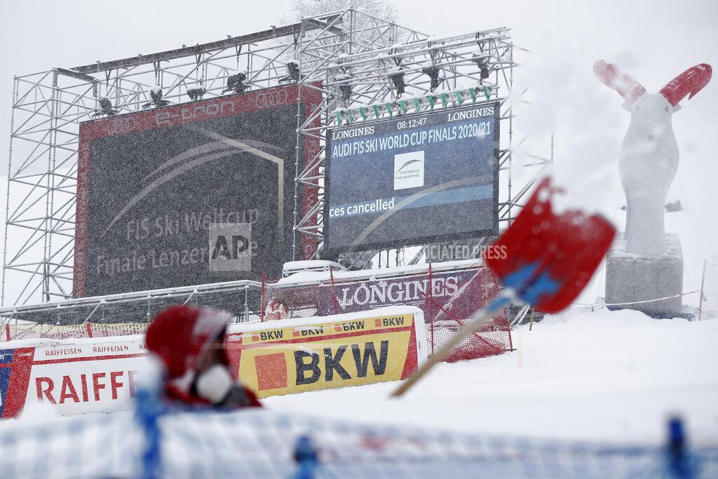 Gabriele Facciotti A man is clearing snow in the finish area as the alpine ski, men's and women's World Cup downhill were cancelled due to weather conditions, in Lenzerheide, Switzerland, Wednesday, March 17, 2021. (AP Photo/Gabriele Facciotti)