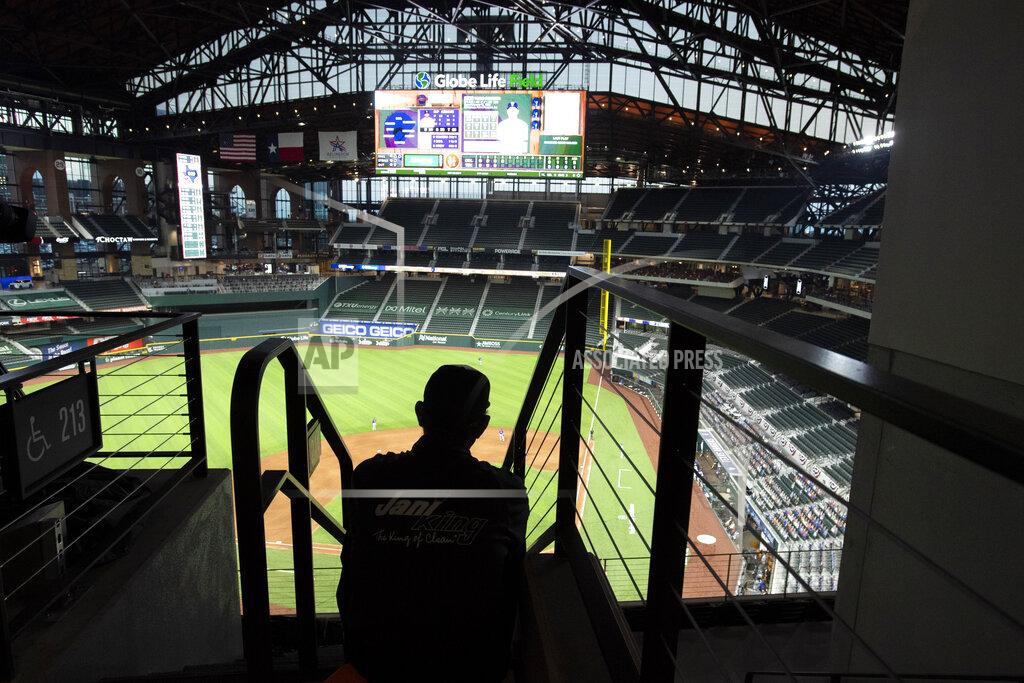 Jeffrey Mcwhorter Globe Life Park custodian Erazmo Gonzalez watches from the upper deck during an opening day baseball game between the Texas Rangers and the Colorado Rockies, Friday, July 24, 2020, in Arlington, Texas. (AP Photo/Jeffrey McWhorter)