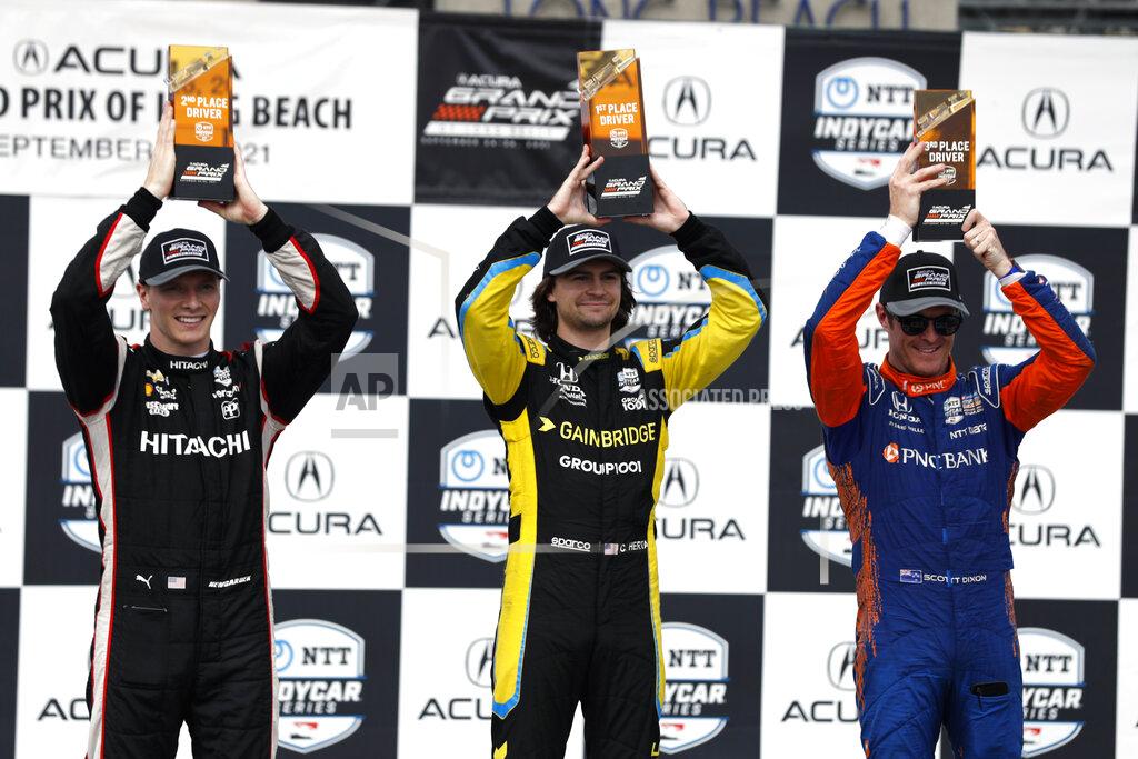 Alex Gallardo Driver Colton Herta, center, holds up his first place trophy for photographers with second place winner Josef Newgarden, left, and third place winner Scott Dixon, right, during an IndyCar auto race at the Grand Prix of Long Beach, Sunday, Sept. 26, 2021, in Long Beach, Calif. (AP Photo/Alex Gallardo)