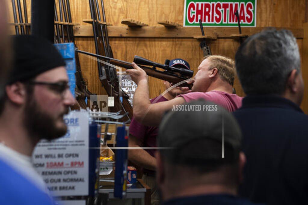 Joe Lamberti FILE - In this Friday, March 20, 2020, file photo, a customer looks through a rifle scope as Bob's Little Sport Shop bustles with customers, in Glassboro, N.J. Gun retailers in New Jersey can remain open as essential businesses during the coronavirus outbreak. After a year of pandemic lockdowns, mass shootings are back, but the guns never went away. As the U.S. inches toward a post-pandemic future, guns are arguably more present in the American psyche and more deeply embedded in American discourse than ever before. The past year's anxiety and loss fueled a rise in gun ownership across political and socio-economic lines. (Joe Lamberti/Camden Courier-Post via AP, File)