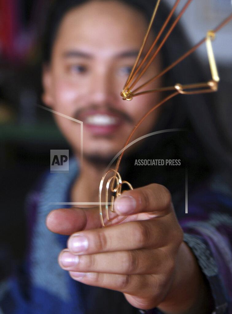 Barbara Haddock Taylor Baltimore street artist Reed Bmore makes wire sculptures of various sizes that he sometimes displays outside in different locations in Baltimore, Md., Sept. 2, 2021. Reed Bmore is accustomed to seeing his pieces fly high over the heads of the public as the ingenious wire sculptures dangle ― cheekily, if illicitly — from light fixture and traffic signal power cables. (Barbara Haddock Taylor/The Baltimore Sun via AP)