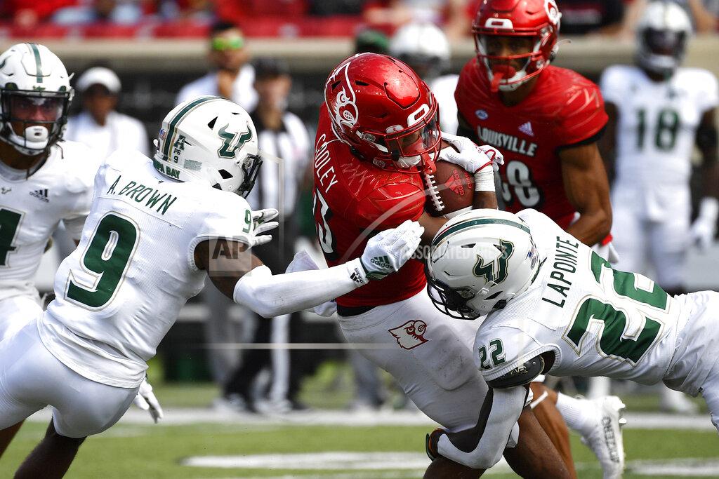 Timothy D. Easley Louisville running back Trevion Cooley (23) is tackled by South Florida defensive back Aamaris Brown (9), and defensive back Mekhi LaPointe (22) during the second half of an NCAA college football game in Louisville, Ky., Saturday, Sept. 24, 2022. Louisville won 41-3. (AP Photo/Timothy D. Easley)