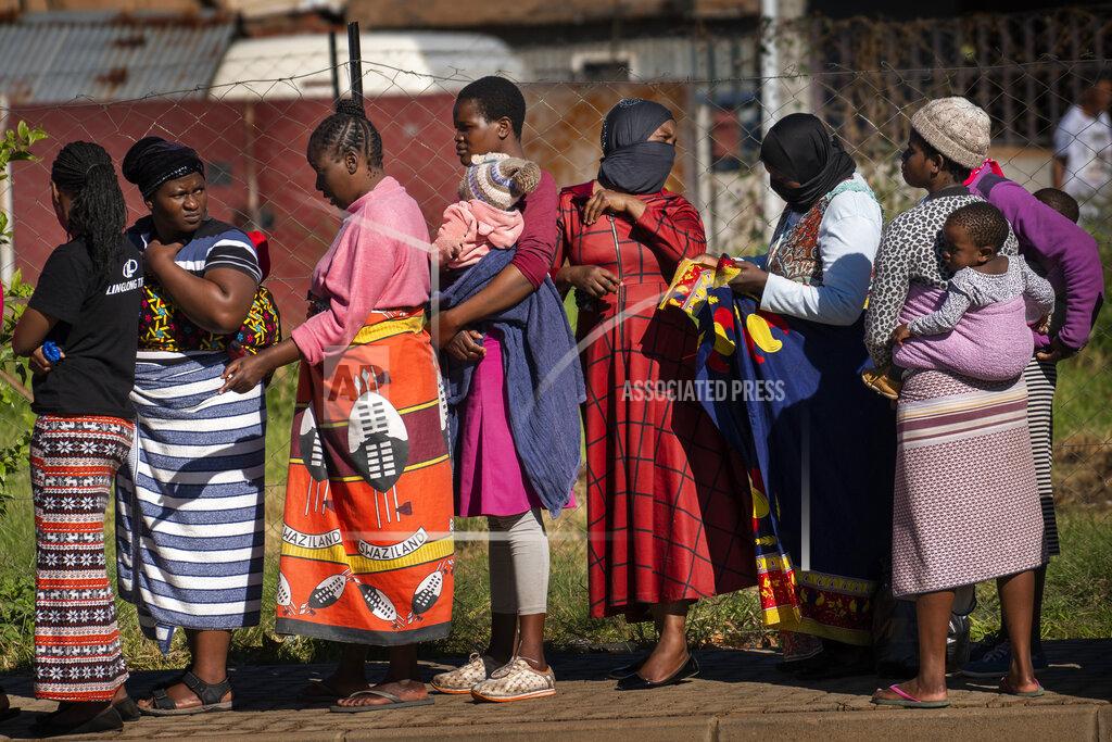 Jerome Delay FILE- In this file photo taken Thursday, April 30, 2020, Women carrying their children lineup to receive vegetables from the Jan Hofmeyer community services in the Vrededorp neighborhood of Johannesburg. South Africa is struggling to balance its fight against the coronavirus with its dire need to resume economic activity. The country with the Africa’s most developed economy also has its highest number of infections — more than 19,000. (AP Photo/Jerome Delay, file)