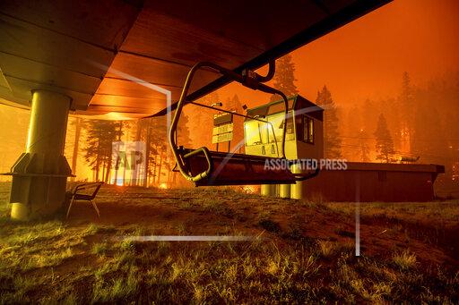 FILE — Seen in a long camera exposure, the Caldor Fire burns at Sierra-at-Tahoe ski resort on Monday, Aug. 30, 2021, in Eldorado National Forest, Calif. A father and son have been arrested on suspicion of starting a massive California wildfire that forced tens of thousands to flee the Lake Tahoe area earlier this year, officials said Wednesday, Dec. 8, 2021. The El Dorado County District Attorney’s office said in a statement that David Scott Smith and his son, Travis Shane Smith, are accused of reckless arson in a warrant issued before formal charges are filed. (AP Photo/Noah Berger, File)