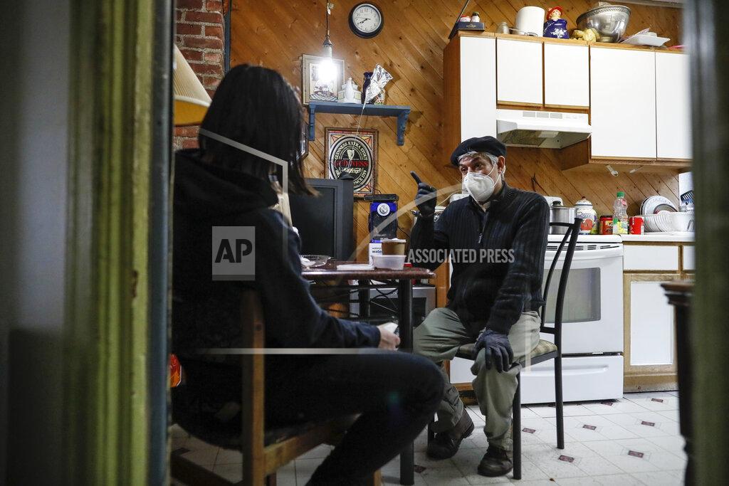 John Minchillo Fabian Arias, a Lutheran pastor with Saint Peter's Church in Manhattan, right, speaks with Jason Mejia, left, to whom he provides legal guardianship in Mejia's kitchen, Thursday, May 14, 2020, in West New York, N.J. (AP Photo/John Minchillo)