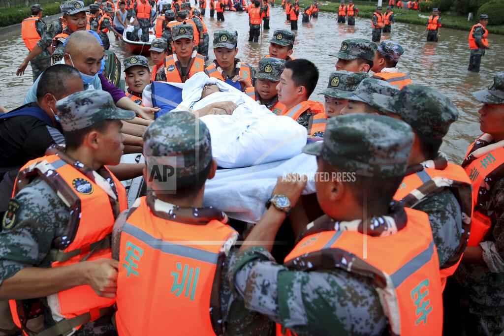 Uncredited Chinese military personnel evacuate residents from a hospital where about 3,000 people were trapped by the flood in Zhengzhou in central China's Henan province Thursday, July 22, 2021. Residents of the storm-ravaged central Chinese city of Zhengzhou on Thursday were shoveling mud from their homes and hauling away wrecked cars and piles of destroyed belongings following floods that killed at least 33 people in the city and surrounding areas. (Chinatopix Via AP)