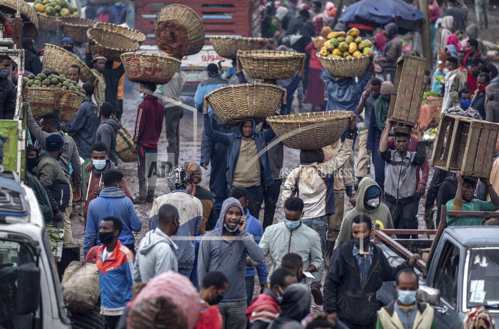 Mulugeta Ayene FILE - In this Thursday, Sept. 10, 2020 file photo, traders carry baskets of vegetables through muddy pathways in Atkilt Tera, the largest open-air vegetable market, in the capital Addis Ababa, Ethiopia. President Donald Trump has largely neglected Africa, with one glaring exception: the tussle between two of the continent's most powerful countries, Ethiopia and Egypt, over a massive dam project on a tributary of the Nile. (AP Photo/Mulugeta Ayene, File)
