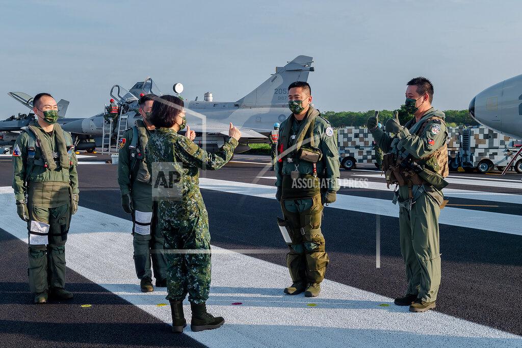 Uncredited In this photo released by the Taiwan Presidential Office, Taiwanese President Tsai Ing-wen, center, speaks with military personnel near aircraft parked on a highway in Jiadong, Taiwan, Wednesday, Sept. 15, 2021. Four military aircraft landed on the highway and took off again on Wednesday as part of Taiwan's five-day Han Guang military exercise designed to prepare the island's forces for an attack by China, which claims Taiwan as part of its own territory. (Taiwan Presidential Office via AP)