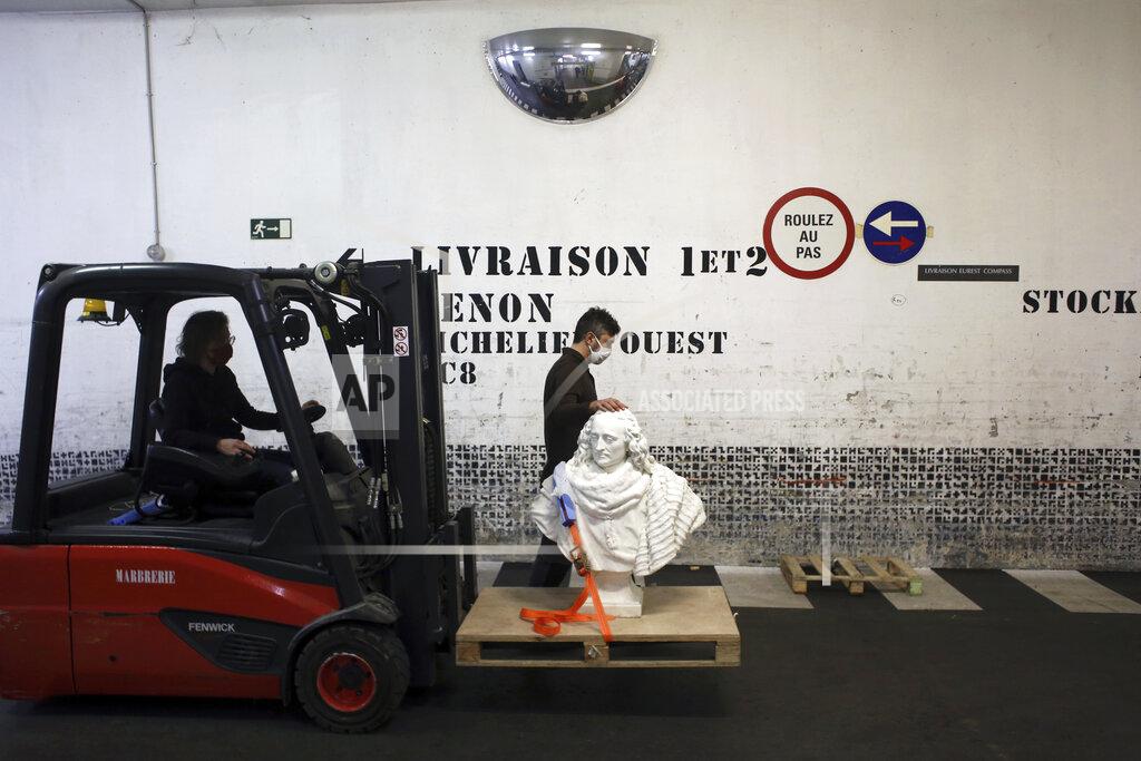 Thibault Camus Workers transport a bust of Guillaume de Lamoignon by French sculptor Francois Girardon, in the Louvre museum, in Paris, Wednesday, Feb. 17, 2021. The forced closure has granted museum officials a golden opportunity to carry out long-overdue refurbishments that were simply not possible with nearly 10 million visitors a year. (AP Photo/Thibault Camus)