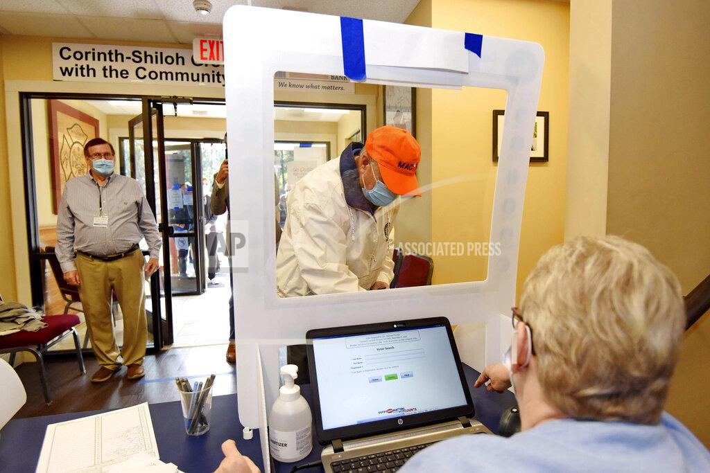 Richard Shiro Republican U.S. Sen. Lindsey Graham, center, checks in to vote at the Corinth-Shiloh Fire Dept. in Seneca, S.C. Tuesday, Nov. 3, 2020. (AP Photo/Richard Shiro)