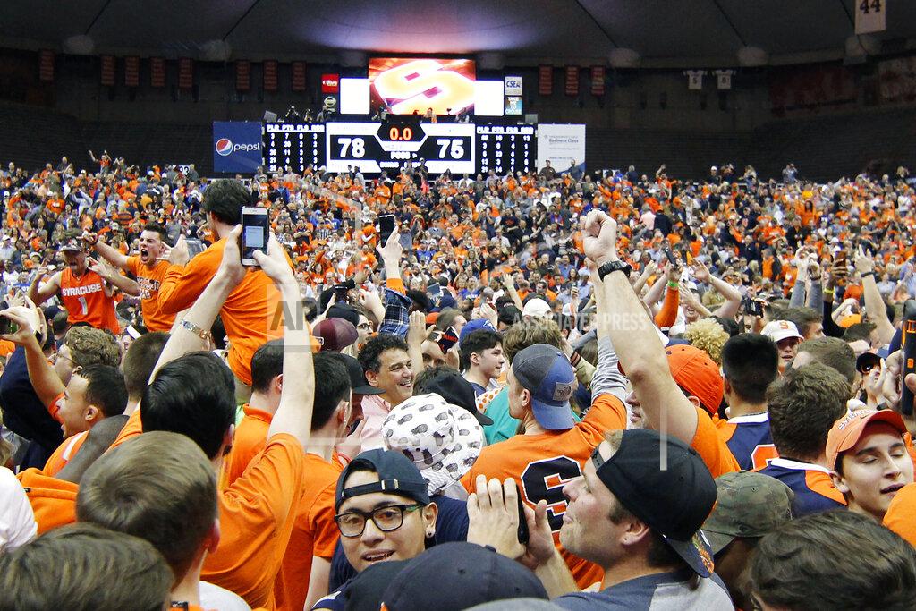 Nick Lisi FILE - In this Feb. 22, 2017, file photo, Syracuse fans celebrate on the court after beating Duke in an NCAA college basketball game in Syracuse, N.Y. The virus that causes COVID-19 is most easily spread when an infected person coughs, sneezes or talks, allowing droplets to land in the mouths or noses of people nearby. That's why most recent guidelines from the Centers for Disease Control continue to preach 6 feet of separation in public setting as among the most important ways to stop the spread. (AP Photo/Nick Lisi, File)