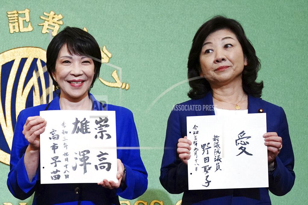 Eugene Hoshiko Sanae Takaichi, left, and Seiko Noda, right, both former internal affairs ministers and candidates for the presidential election of the ruling Liberal Democratic Party, show their motto on cards, during a debate session held by Japan National Press club Saturday, Sept. 18, 2021 in Tokyo. Takaichi and Noda are the first women in 13 years seeking the leadership of the ruling Liberal Democratic Party in an election Wednesday, Sept. 29. (AP Photo/Eugene Hoshiko, Pool)