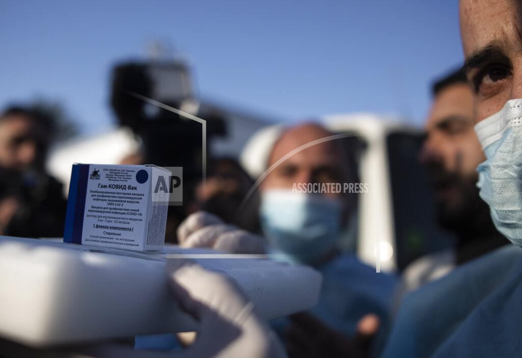 Khalil Hamra A Palestinian medic displays a box of one of 20,000 doses of Russian-made Sputnik V vaccine upon its arrival to Gaza Strip, at the Rafah crossing border with Egypt, Sunday, Feb. 21, 2021. The 20,000 doses of Russia's Sputnik V, donated by the United Arab Emirates and organized by Abbas rival Mohammed Dahlan, entered the Palestinian enclave through its border with Egypt. (AP Photo/Khalil Hamra)