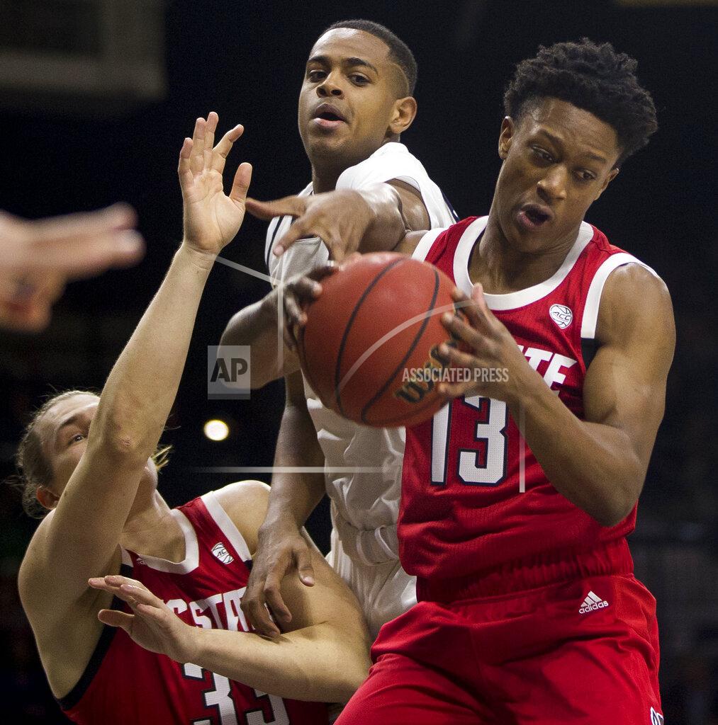 Robert Franklin North Carolina State's C.J. Bryce (13) grabs a rebound over teammate Wyatt Walker (33) and Notre Dame's D.J. Harvey during the first half of an NCAA college basketball game Saturday, Jan. 19, 2019, in South Bend, Ind. (AP Photo/Robert Franklin)