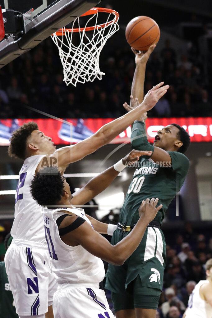 Michigan State forward Marcus Bingham Jr., right, shoots against Northwestern guard Pat Spencer, left, and guard Anthony Gaines during the first half of an NCAA college basketball game Wednesday, Dec. 18, 2019, in Evanston, Ill. (AP Photo/Nam Y. Huh)