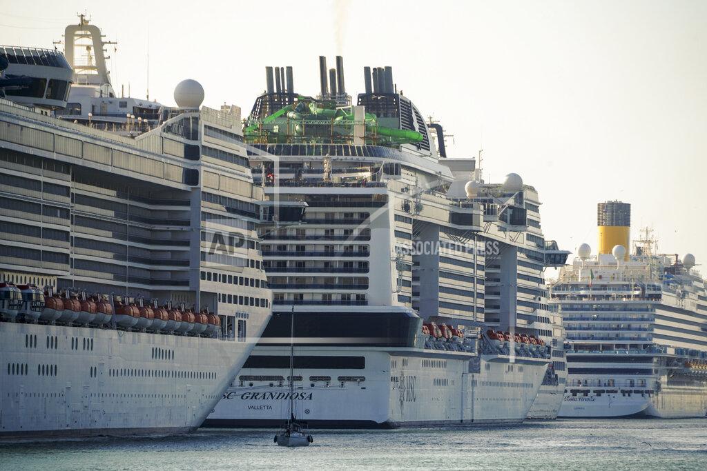 Andrew Medichini A view of the MSC Grandiosa cruise ship, center, in Civitavecchia, near Rome, Wednesday, March 31, 2021. MSC Grandiosa, the world's only cruise ship to be operating at the moment, left from Genoa on March 30 and stopped in Civitavecchia near Rome to pick up more passengers and then sail toward Naples, Cagliari, and Malta to be back in Genoa on April 6. For most of the winter, the MSC Grandiosa has been a lonely flag-bearer of the global cruise industry stalled by the pandemic, plying the Mediterranean Sea with seven-night cruises along Italy’s western coast, its major islands and a stop in Malta. (AP Photo/Andrew Medichini)