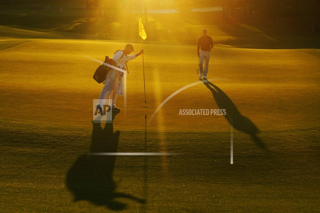 Chris Carlson Caddie John LaCava removes the pin on the ninth green as Tiger Woods prepares to putt during the second round of the Masters golf tournament Friday, Nov. 13, 2020, in Augusta, Ga. (AP Photo/Chris Carlson)