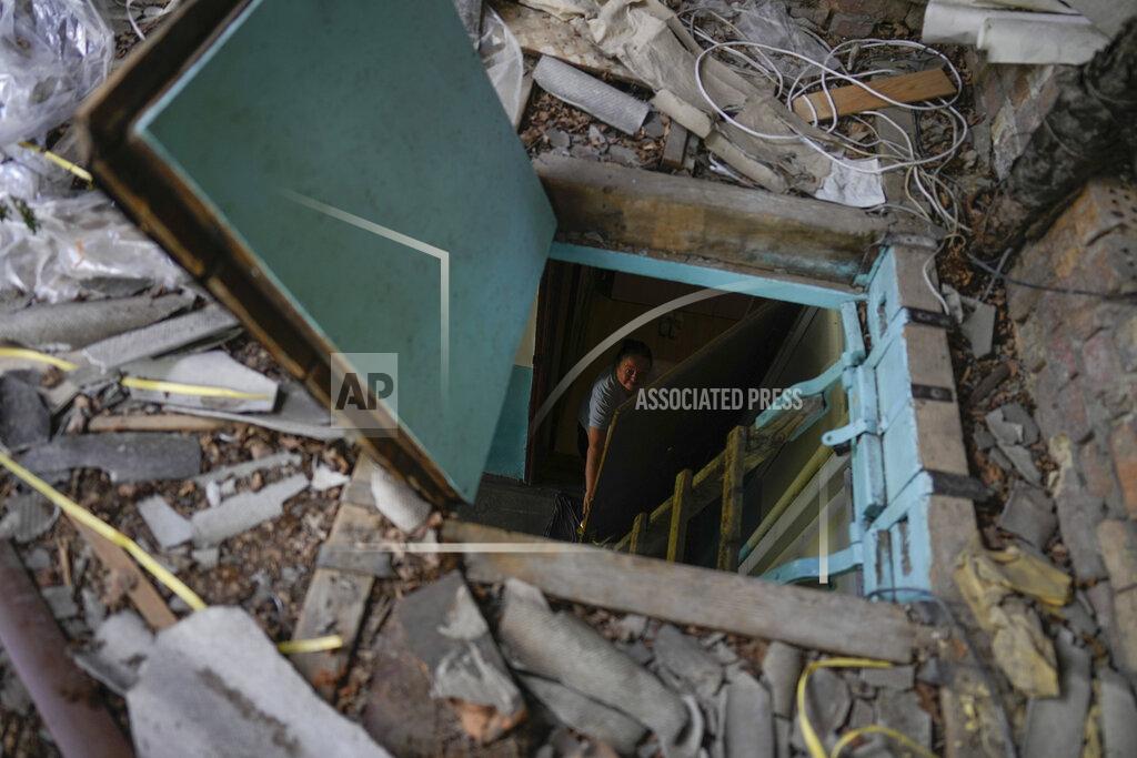 Natacha Pisarenko Liudmyla Voronina opens a skylight window on the roof of her house roof as she stands inside her home that was damaged by attacks in Irpin, on the outskirts of Kyiv, Ukraine, Thursday, May 26, 2022. Voronina lives alone now fearing new attacks or that the roof will fall on her. She used to live with her son and grandchildren, but she does not consider it a safe place for them.(AP Photo/Natacha Pisarenko)