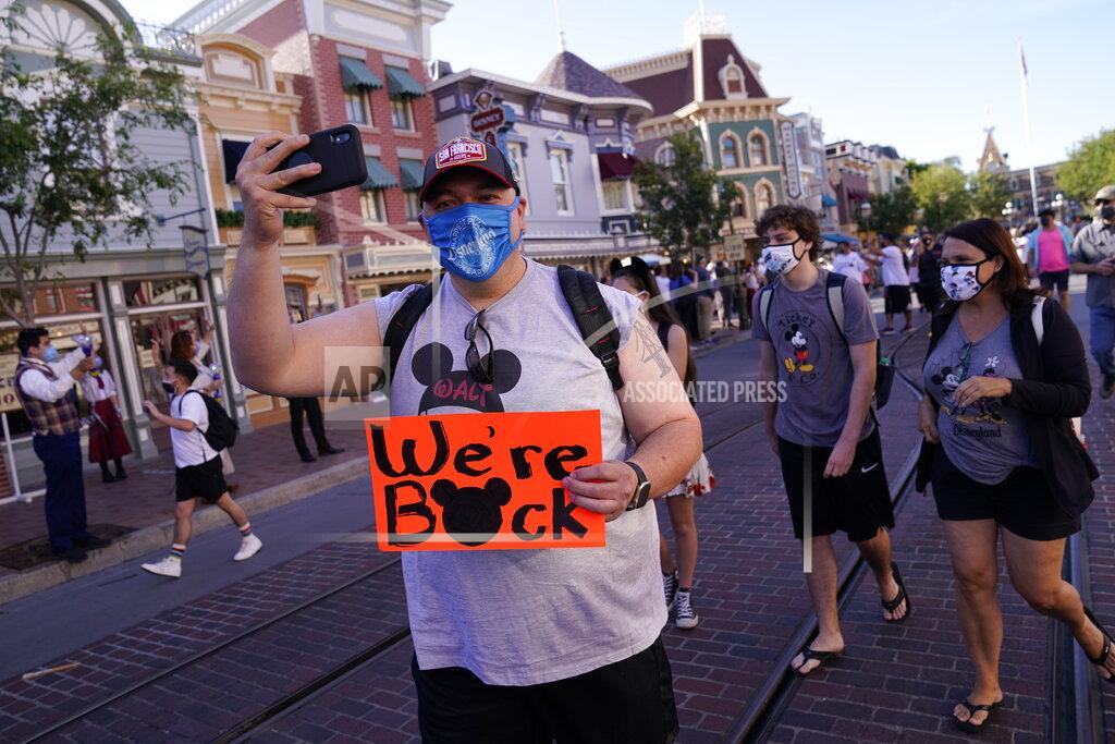 Jae Hong Guests walk down Main Street USA at Disneyland in Anaheim, Calif., Friday, April 30, 2021. The iconic theme park in Southern California that was closed under the state's strict virus rules swung open its gates Friday and some visitors came in cheering and screaming with happiness. (AP Photo/Jae Hong)