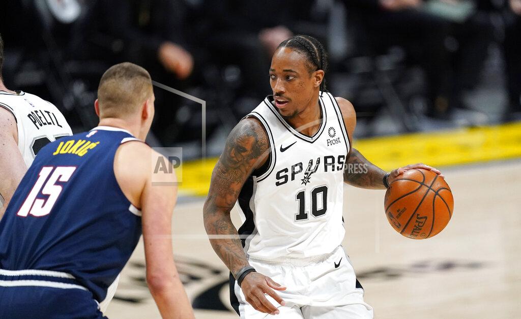 David Zalubowski San Antonio Spurs forward DeMar DeRozan, right, looks to pass the ball as Denver Nuggets center Nikola Jokic defends in the first half of an NBA basketball game Friday, April 9, 2021, in Denver. (AP Photo/David Zalubowski)