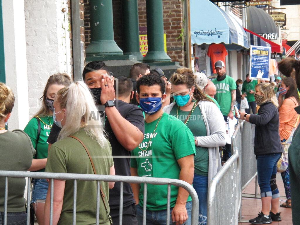 Russ Bynum St. Patrick's Day revelers in masks wait in line outside to get into a bar in Savannah, Ga., Wednesday, March 17, 2021. Despite its 197-year-old parade being cancelled, Savannah welcomed thousands of tourists for the Irish holiday. Some city officials worried the celebration could start an outbreak of the coronavirus. (AP Photo/Russ Bynum)