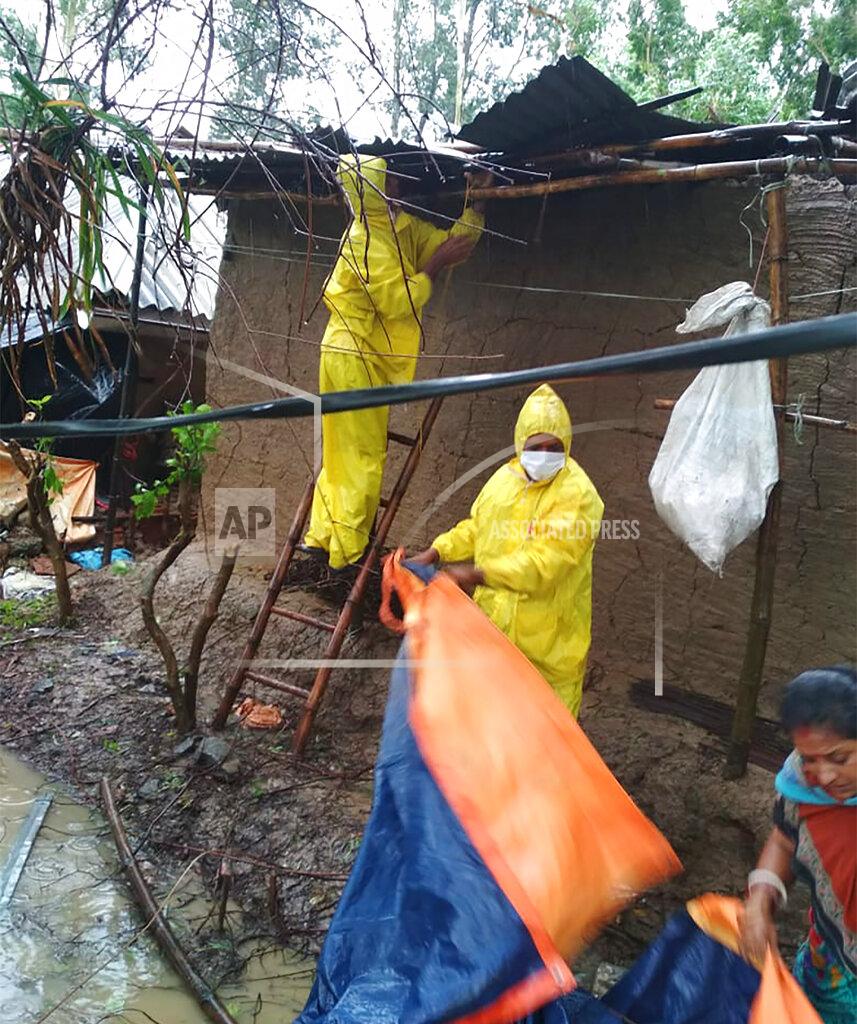 Uncredited This photo provided by the Indian Red Cross Society shows volunteers of the organization fixing homes of villagers after Cyclone Amphan, the equivalent of a category 3 hurricane, hit the area in Bhadrak district of Orissa state, India, Thursday, May 21, 2020. A powerful cyclone ripped through densely populated coastal India and Bangladesh, blowing off roofs and whipping up waves that swallowed embankments and bridges and left entire villages without access to fresh water, electricity and communications. At least 24 people were reported killed Thursday. (Indian Red Cross Society via AP)