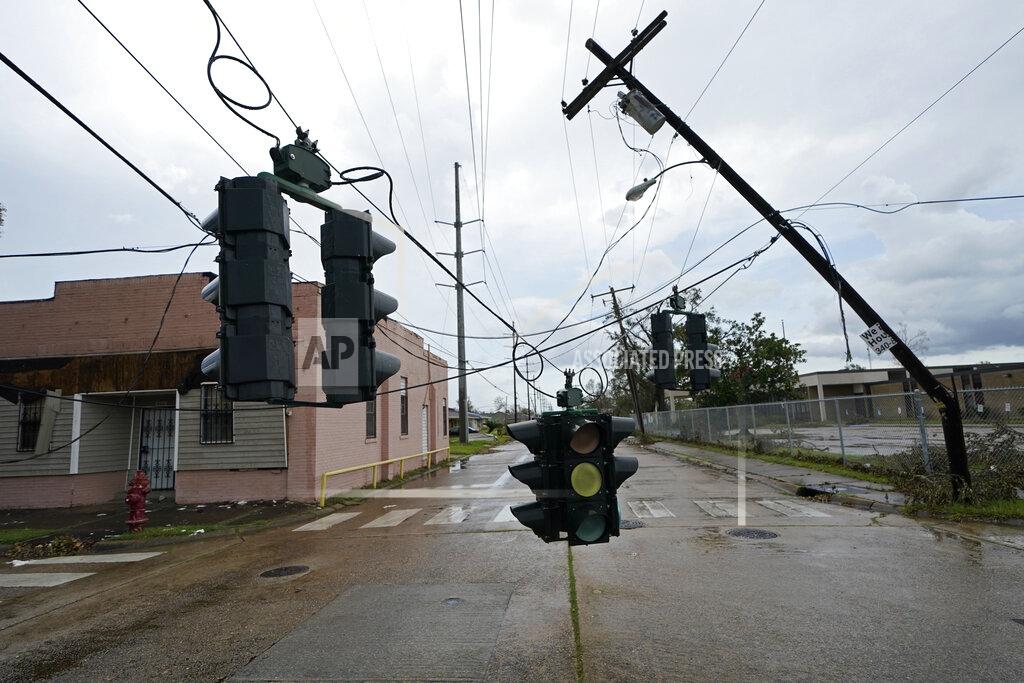 Gerald Herbert Traffic signals dangle close to the roadway from broken utility poles in Lake Charles, La., in the aftermath of Hurricane Laura, Sunday, Aug. 30, 2020. (AP Photo/Gerald Herbert)
