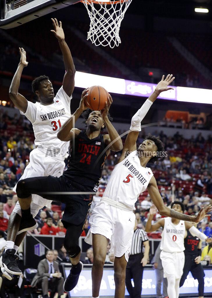 Isaac Brekken San Diego State's Nathan Mensah (31) and Jalen McDaniels (5) defend as UNLV'sJoel Ntambwe shoots during the second half of an NCAA college basketball game in the Mountain West Conference men's tournament Thursday, March 14, 2019, in Las Vegas. (AP Photo/Isaac Brekken)