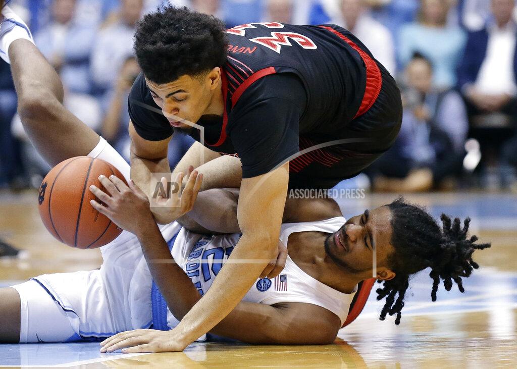 Gerry Broome North Carolina's Coby White, bottoom, and Louisville's Jordan Nwora go to the floor chasing the ball during the second half of an NCAA college basketball game in Chapel Hill, N.C., Saturday, Jan. 12, 2019. Louisville won 83-62. (AP Photo/Gerry Broome)