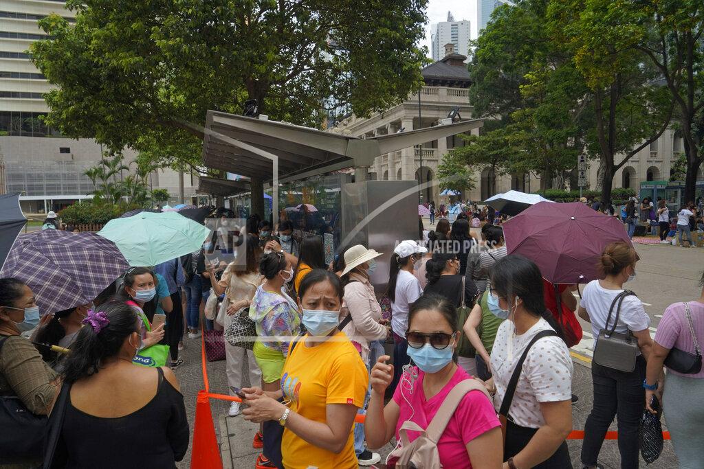 Kin Cheung In this Saturday, May 1, 2021, photo, domestic helpers from the Philippines line up at the temporary testing center for COVID-19, in Hong Kong. Hong Kong officials have dropped a plan to make it mandatory for foreign domestic workers to be vaccinated against the coronavirus, after the move drew criticism that it was discriminatory. (AP Photo/Kin Cheung)