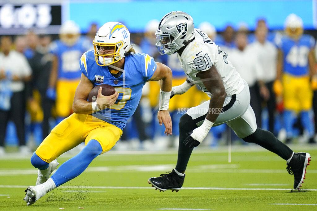 Ashley Landis Los Angeles Chargers quarterback Justin Herbert runs with the ball as Las Vegas Raiders defensive end Yannick Ngakoue defends during the second half of an NFL football game Monday, Oct. 4, 2021, in Inglewood, Calif. (AP Photo/Ashley Landis)
