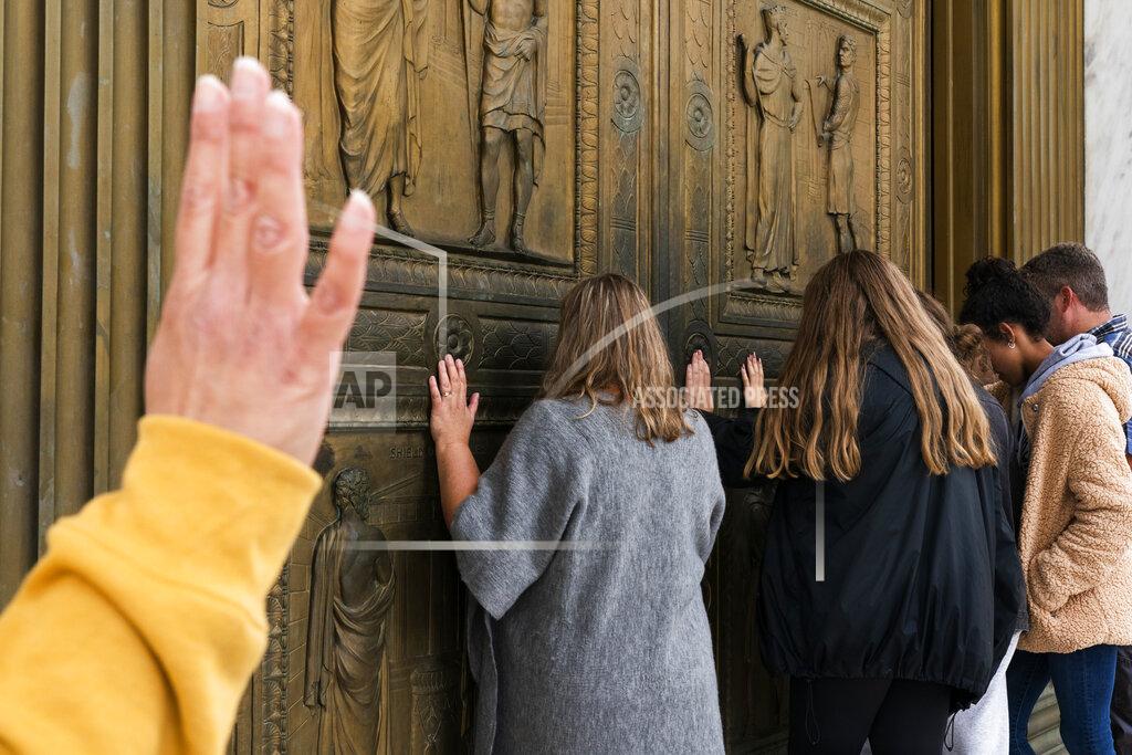 Jacquelyn Martin People pray to Jesus at the door of the Supreme Court in support of Supreme Court nominee Amy Coney Barrett, Monday, Oct. 26, 2020, outside the Supreme Court on Capitol Hill in Washington. (AP Photo/Jacquelyn Martin)