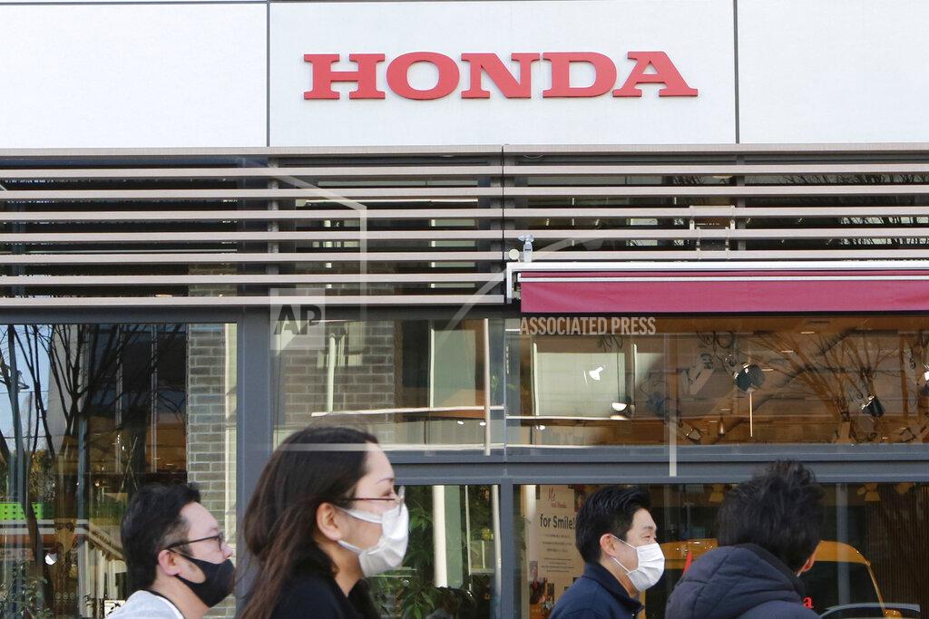 Koji Sasahara People wearing face masks walk in front of a Honda Motor Co. showroom in Tokyo, Tuesday, Feb. 9, 2021. Japanese automaker Honda reported Tuesday its fiscal third quarter profit more than doubled to 284 billion yen ($2.7 billion) despite the coronavirus pandemic as auto sales grew in Japan and the U.S. (AP Photo/Koji Sasahara)
