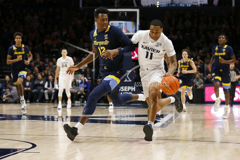 Sam Greene Xavier guard Dwon Odom (11) drives to the basket against Marquette forward Olivier-Maxence Prosper (12) in the first half of an NCAA college basketball game at Cintas Center in Cincinnati on Saturday, Dec. 18, 2021. (Sam Greene/The Cincinnati Enquirer via AP)