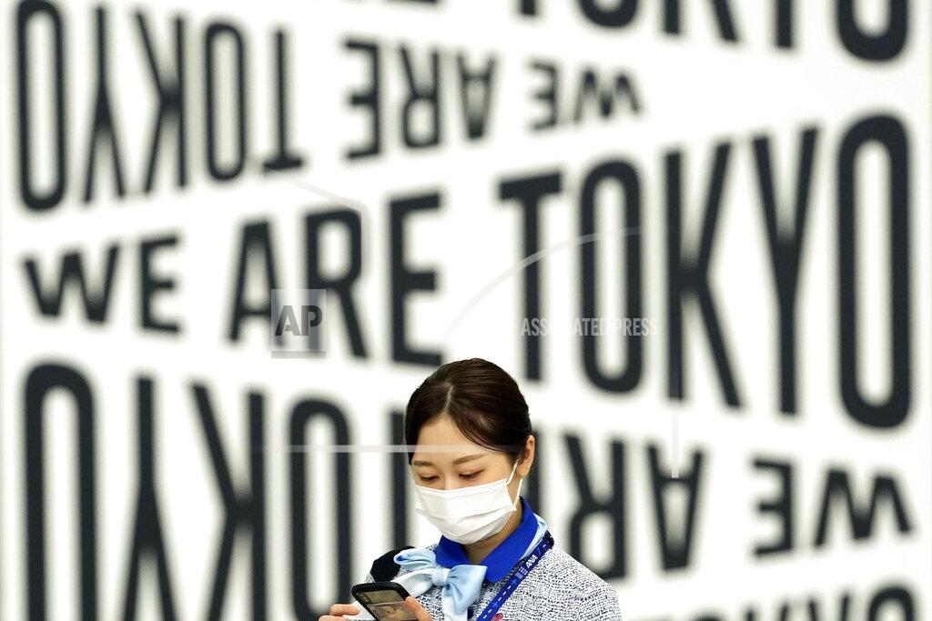 Eugene Hoshiko An employee wearing a protective mask to help curb the spread of the coronavirus walks through Haneda Airport Monday, Aug. 2, 2021, in Tokyo. (AP Photo/Eugene Hoshiko)