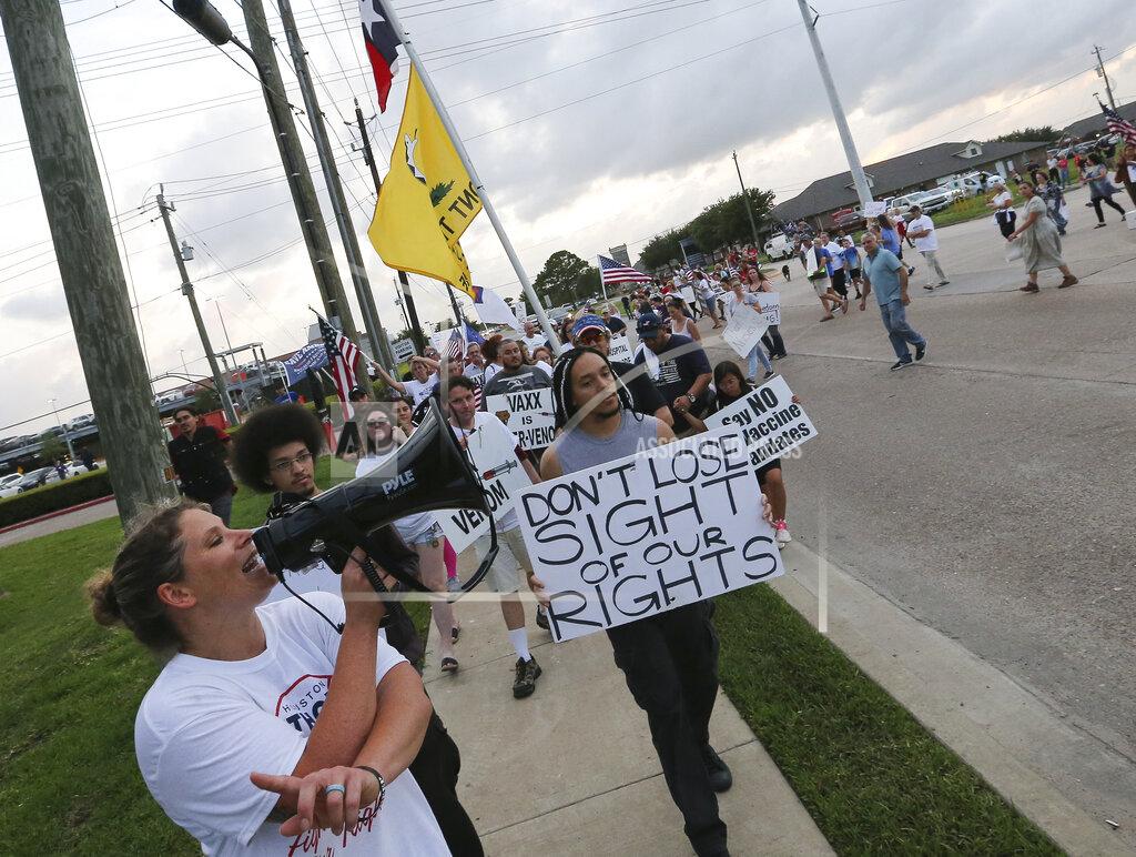Yi-Chin Lee Jennifer Bridges, left, leads people marching past protest Houston Methodist Baytown Hospital to protest against the hospital system's rule of firing any employee who is not immunized by Monday, June 7, 2021, in Baytown, Texas. Public and Houston Methodist staff who have refused the COVID-19 vaccine so far participated a gathering and march. (Yi-Chin Lee/Houston Chronicle via AP)