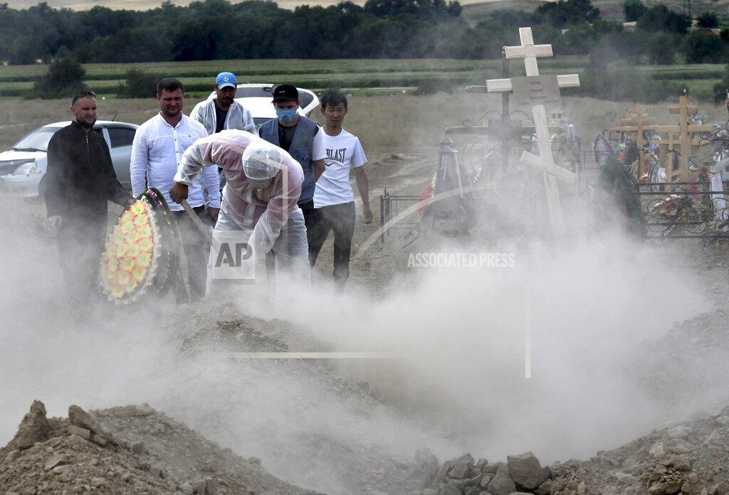 Vladimir Voronin Funeral workers disinfect a grave as they bury the victim of the coronavirus at a cemetery outside Bishkek, Kyrgyzstan, Thursday, July 23, 2020. Coronavirus cases surged in Kyrgyzstan after authorities lifted a tight lockdown in May, overwhelming the health care system. But now thousands of volunteers are helping medical workers in busy hospitals, using cars into makeshift ambulances and finding protective gear, drugs, supplies and equipment. (AP Photo/Vladimir Voronin)