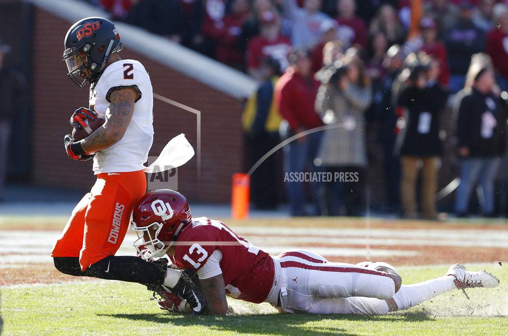 Alonzo Adams Oklahoma State wide receiver Tylan Wallace (2) is tackled by Oklahoma cornerback Tre Norwood (13) just before the end zone in the first quarter of an NCAA college football game in Norman, Okla., Saturday, Nov. 10, 2018. (AP Photo/Alonzo Adams)