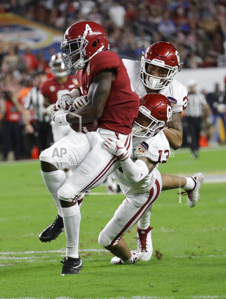 Lynne Sladky Oklahoma safety Robert Barnes (20) and cornerback Tre Norwood (13) tackle Alabama wide receiver Jerry Jeudy (4), during the first half of the Orange Bowl NCAA college football game, Saturday, Dec. 29, 2018, in Miami Gardens, Fla. (AP Photo/Lynne Sladky)