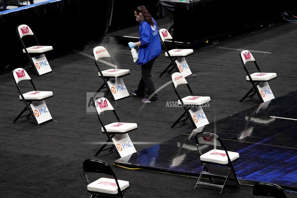 Jeff Roberson A worker cleans chairs serving as a socially distanced bench for teams after it was announced that an NCAA college basketball game in the quarterfinal round of the Missouri Valley Conference men's tournament between Northern Iowa and Drake has been cancelled Friday, March 5, 2021, in St. Louis. (AP Photo/Jeff Roberson)