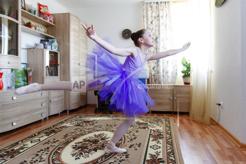Anton Basanaev Alexandra Kustova, shows how she dances prior to an interview in her family's apartment in Yekaterinburg, a city in the Urals, Russia on Thursday, May 7, 2020. For 12-year-old Alexandra, self-isolation during the coronavirus pandemic turned out to be a blessing in disguise. Now that all the studies are conducted online, not only does she have more time for her two favorite hobbies _ ballet and jigsaw puzzles _ she spends more time with her family and helps out her grandmother, who lives in the same building two floors down. (AP Photo/Anton Basanaev)