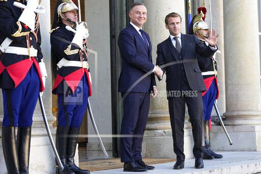 French President Emmanuel Macron, right, and Poland's President Andrzej Duda shake hands before a working lunch at the Elysee Palace Wednesday, Oct. 27, 2021 in Paris. The European Union's top court has ordered Poland to pay 1 million euros a day ($1.2 billion) over the country's longstanding dispute with the bloc over judicial independence. (AP Photo/Michel Euler)