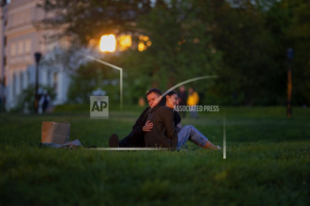 Emilio Morenatti Stepan and Anastasia sit at a public park as the sun sets in Kyiv Ukraine on Tuesday, May 10, 2022. (AP Photo/Emilio Morenatti)