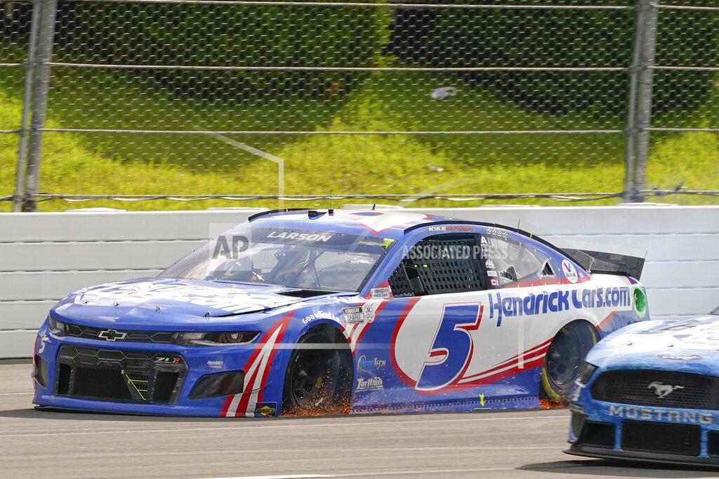 Matt Slocum Sparks fly from under the race car of Kyle Larson (5) as he drives towards the finish line after being passed by Alex Bowman to lose the lead on the last lap of a NASCAR Cup Series auto race at Pocono Raceway, Saturday, June 26, 2021, in Long Pond, Pa. Bowman won the race. (AP Photo/Matt Slocum)