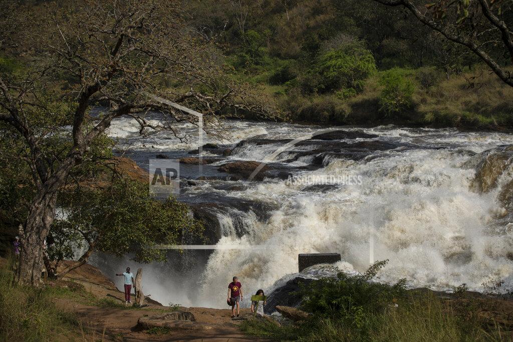 Uncredited Tourists walk at the top of the waterfalls in Murchison Falls National Park, northwest Uganda, on Feb. 22, 2020. The East Africa Crude Oil Pipeline, a controversial oil project that would connect oilfields in the park to a port in Tanzania is in breach of global environmental and human rights guidelines for banks, according to a new report by Inclusive Development International on Tuesday, July 5. (AP Photo)