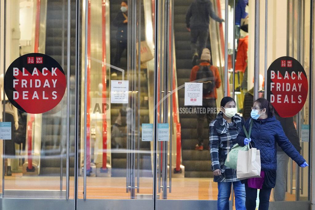 Mary Altaffer Black Friday shoppers wear face masks and gloves as the leave the Uniqlo store along Fifth Avenue, Friday, Nov. 27, 2020, in New York. (AP Photo/Mary Altaffer)