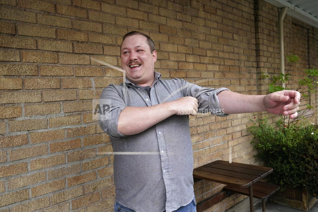 Elaine Thompson Nate Mullins, a former bartender from Oak, Harbor, Wash., who quit his job last November after clashing with managers over enforcing mask rules, pulls up his sleeves as he readies to pose for a photo Monday, May 17, 2021, in Mount Vernon, Wash. There's a wild card in the push to return to post-pandemic life: many workers don't want to return to the jobs they once had. Mullins' unemployment checks don't match what he was making at the bar, but they're enough to get by while he looks for jobs that would provide health care and retirement benefits. (AP Photo/Elaine Thompson)