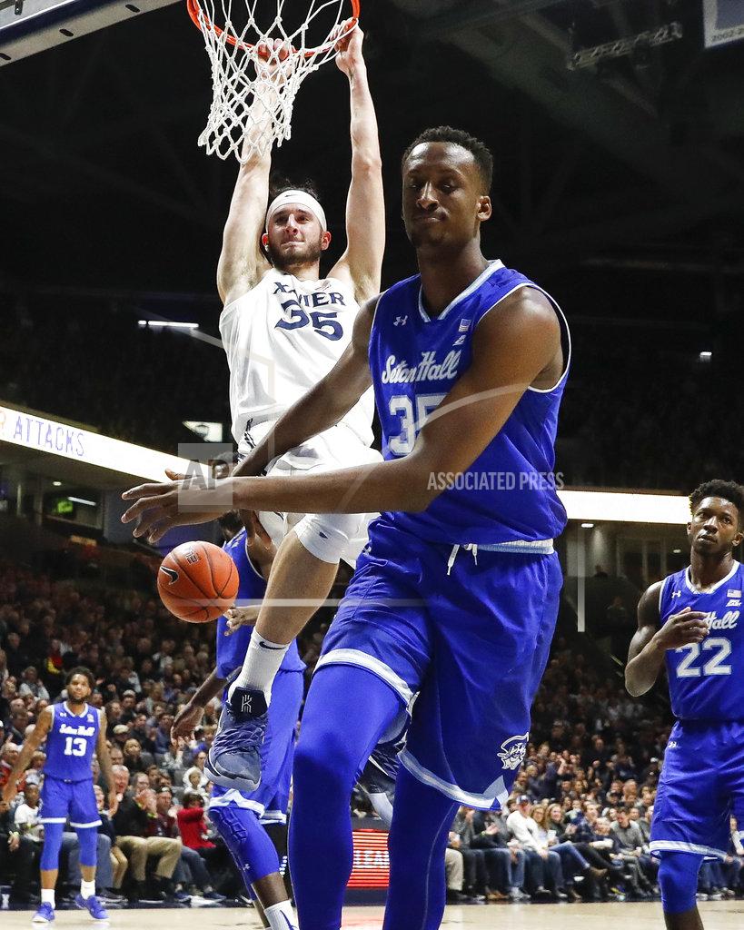 John Minchillo Xavier's Zach Hankins hangs from the rim after a dunk next to Seton Hall's Romaro Gill, front, during the first half of an NCAA college basketball game Wednesday, Jan. 2, 2019, in Cincinnati. (AP Photo/John Minchillo)