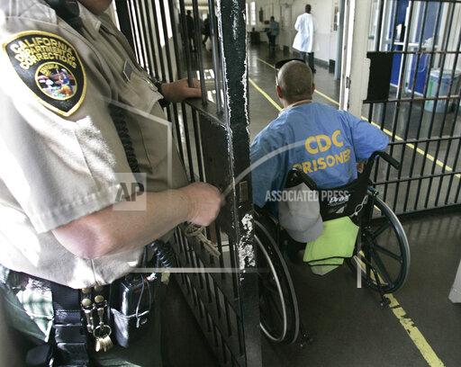 FILE - A wheelchair-bound inmate wheels himself through a checkpoint at the California Medical Facility in Vacaville, Calif., on April 9, 2008. California corrections officials have begun limiting medical parole only to inmates so ill they are on ventilators. They are citing a federal rule change as the reason inmates who are quadriplegic or have other severe permanent disabilities no longer can be placed in nursing homes. (AP Photo/Rich Pedroncelli, File)